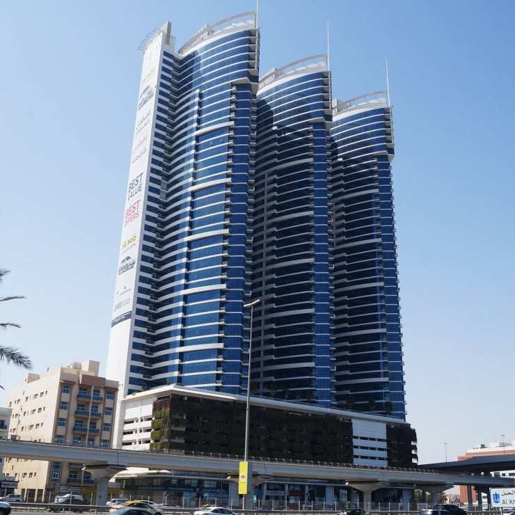 Tall blue and white building with a clear blue sky dubai